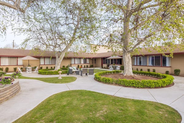 Outdoor courtyard area with seating and trees at San Joaquin Nursing and Rehabilitation Center