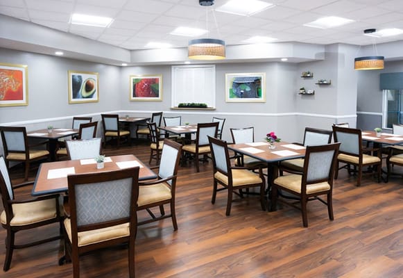 Dining room with tables and chairs set up for residents