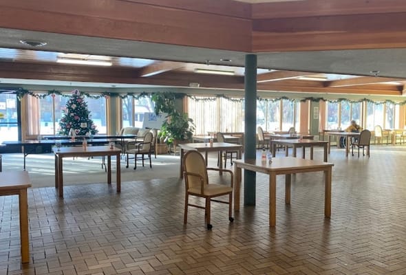 Interior view of a community room with tables and holiday decor