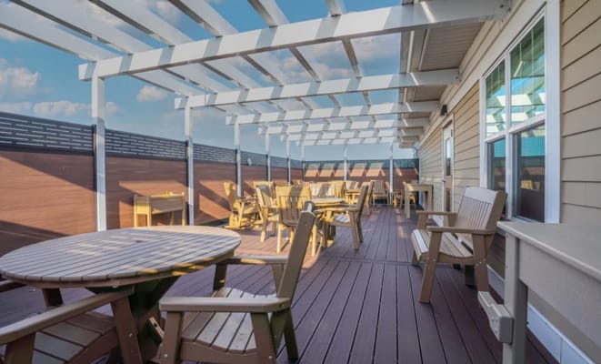 Outdoor seating area with chairs and tables under a pergola