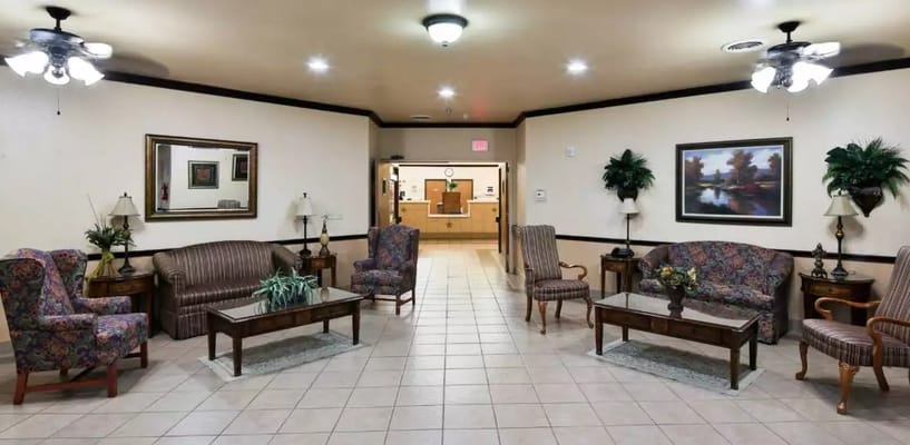 Lobby area with floral chairs and a brown couch