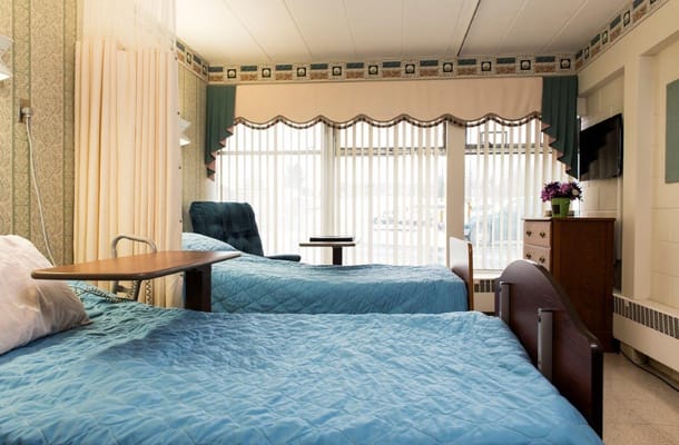 Bedroom with two beds and a view of the outside.