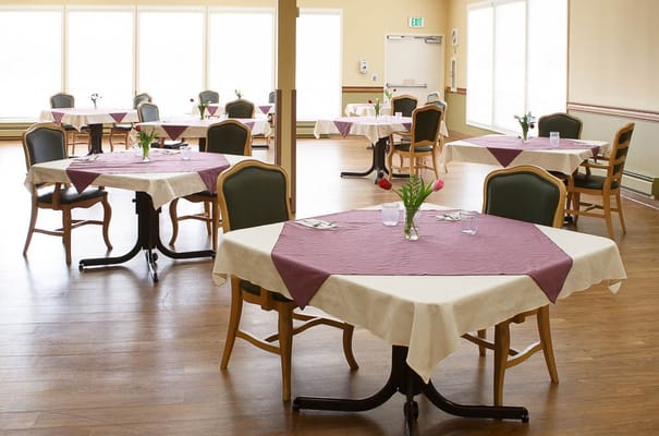 Dining room setup with tables and floral centerpieces