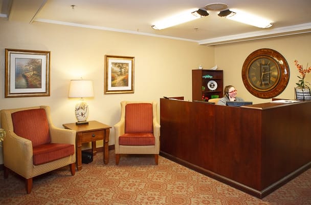 Reception area with seating and staff member at desk
