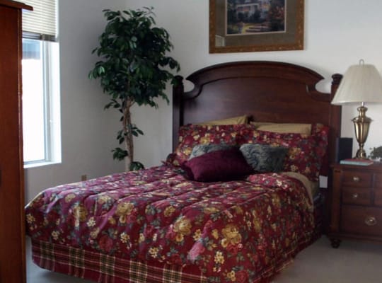 Cozy resident room with a floral bedspread and bedside lamp
