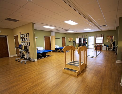 Interior of rehabilitation room with parallel bars and exercise equipment