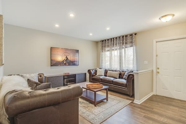 Spacious living room with leather sofas and a TV