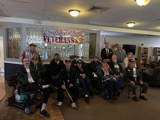 Group of veterans posing for a photo in Sunridge Village common area