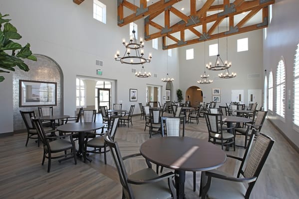 Dining room featuring wooden tables and chairs with chandeliers.