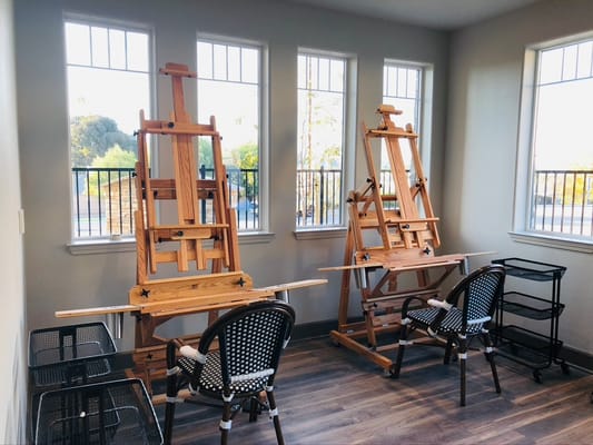 Wooden easels and chairs in a sunny art studio