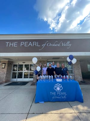 Staff and residents celebrating outside the facility entrance