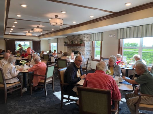 Seniors dining together in a lively dining room.