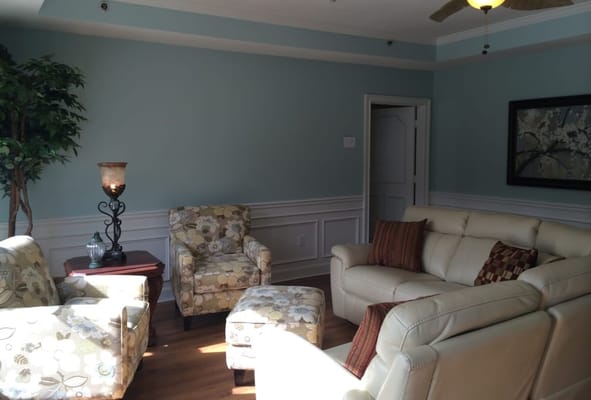 A cozy living room with floral chairs and a modern sofa