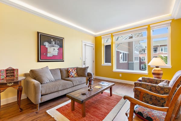 Comfortable living room with sofa, coffee table, and colorful decor.