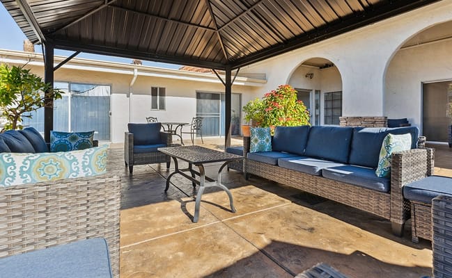 Comfortable outdoor seating area with blue cushions and potted plants.