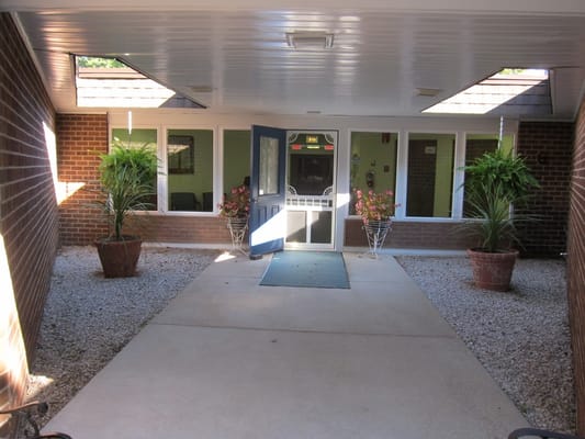 Entrance area of Village House with planters and glass door.