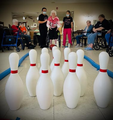 Residents participating in a bowling activity indoors