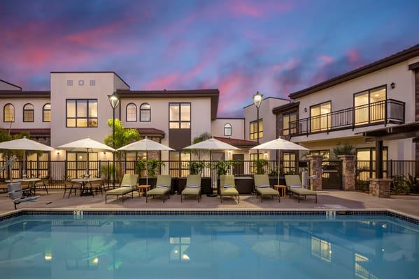 View of the pool area surrounded by lounge chairs and umbrellas at Westmont of Carmel Valley.