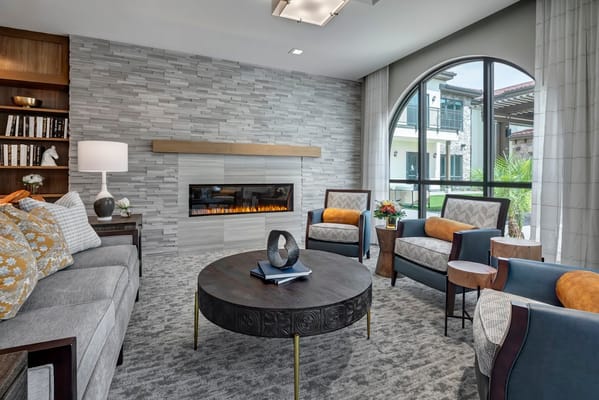 Modern living room with a fireplace and seating area.