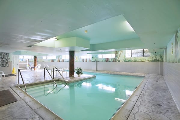 Indoor pool area with light blue walls and chairs