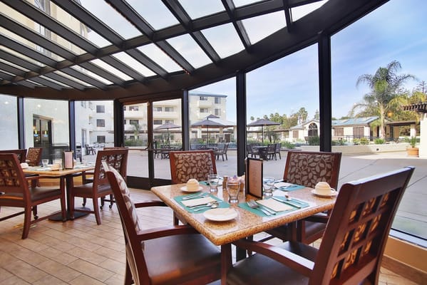 Bright dining room with tables overlooking an outdoor patio