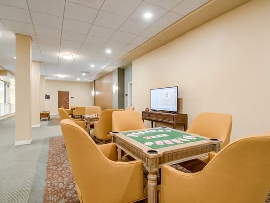Cozy game room with orange chairs and a poker table
