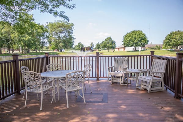 Outdoor seating area by the pond at Westwood Trails.