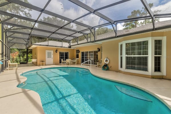 A pool area with seating and large windows