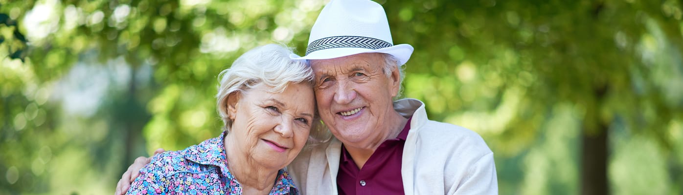 A senior couple smiling together outdoors