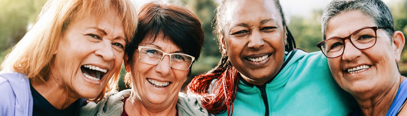 Four smiling women enjoying each other's company outdoors