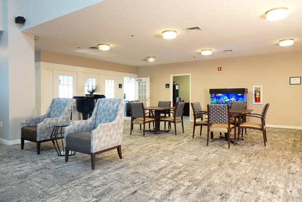 Bright common area with seating and an aquarium