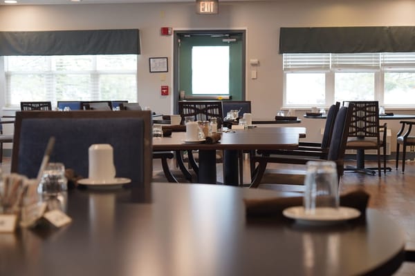Dining room set up for residents with plates and glasses