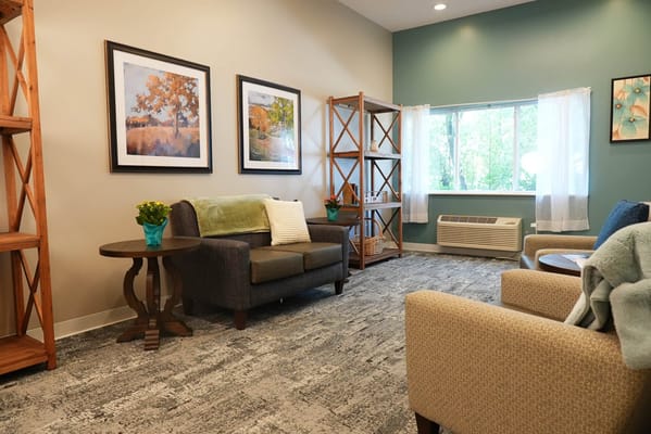 Cozy common area with seating and windows.