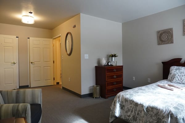 Interior view of a resident room with a bed and dresser