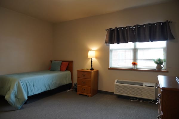 Cozy private room with a bed and lamp