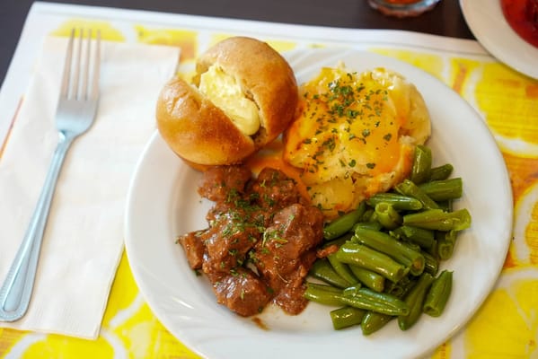 A plate of food with meat, potatoes, and green beans.