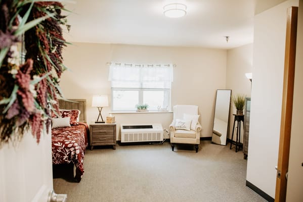 Cozy private resident room with a bed and chair