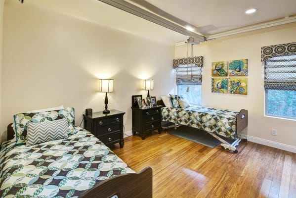 Brightly lit bedroom with two beds and decorative bedding