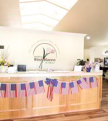 Wooden reception desk decorated with small American flags and flowers