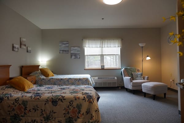 Cozy bedroom with two beds and a reading chair