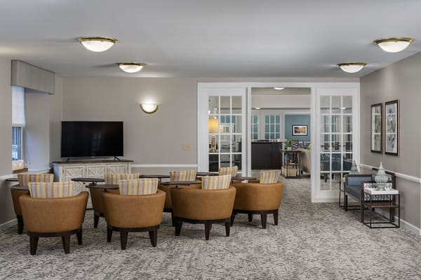 Common area with seating and television in a senior living facility