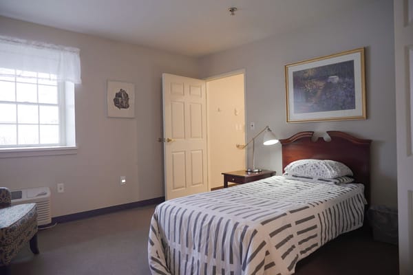 Private resident room with a bed and chair