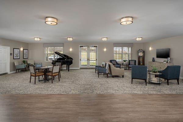 Bright and inviting common area with seating and a piano
