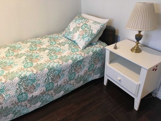 Cozy bedroom with a single bed and a bedside lamp