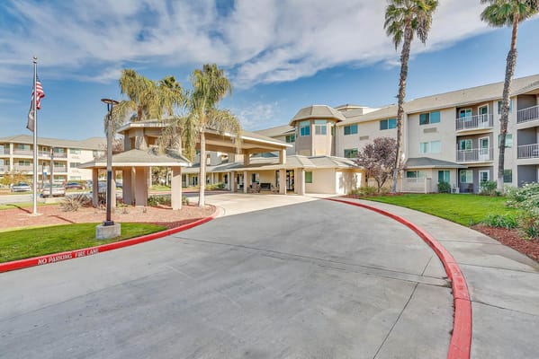 Entrance view of The Remington Senior Living facility with palm trees.