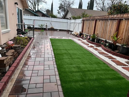 A well-maintained outdoor space with synthetic grass and pavers