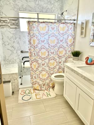 A clean and modern bathroom with floral shower curtain