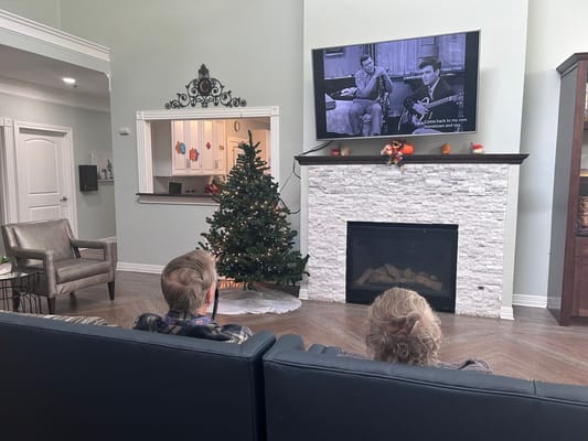 Residents enjoying a movie in a cozy common area