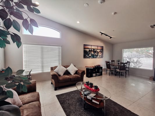 Spacious living room with seating and dining area in Gifts of Grace Assisted Living.