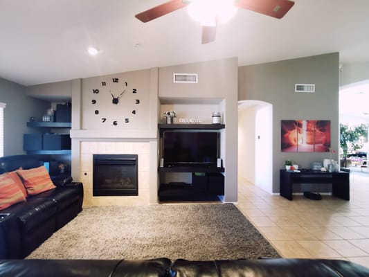Spacious living room with a fireplace and large clock